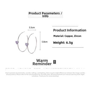 Detail view of 18K gold plated C-shaped hoop earrings with purple zircon heart details