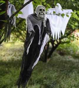 Halloween hanging ghost props in black and white hanging on tree branches outdoors