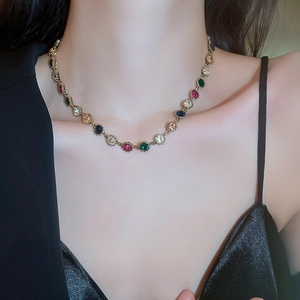 Close-up of a vintage colorful gemstone necklace with gold setting on model neck