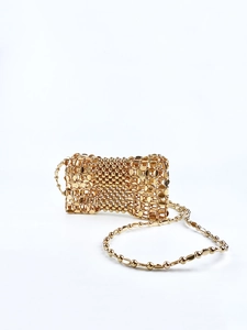Detail of hand-woven gold metallic mesh bag with elegant chain shoulder strap