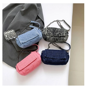 Quattro borse di denim con catena, azzurre, blu navy, rosa e grigio slavato, disposte su fondo bianco