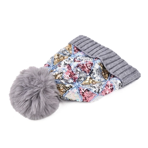 Dettaglio di paillettes multicolori e pompon di pelliccia sintetica grigia su cappello