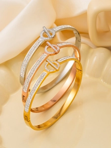 Detailansicht dreifarbiger minimalistischer Armbänder mit Pavé-Diamanten auf Satin