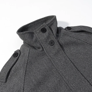 Detail of grey wool coat showing high collar, shoulder epaulettes and black button texture