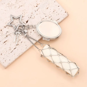 Detail of silver mesh lipstick holder pendant with star clip and bow on stone base