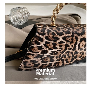 Close-up of leopard print handbag with unique twisted gold metal handle and leather strap