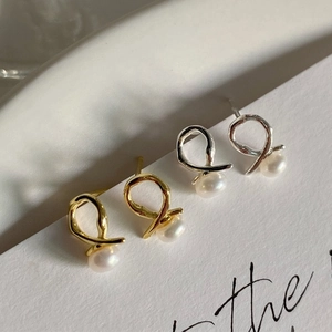 Detail view of 925 silver cross pearl earrings in gold and silver finishes