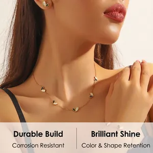Détail d'un ensemble de chaînes dorées avec pendentifs en forme de cœur portés par un mannequin