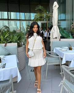 Dettaglio completo di completo bianco in maglia traforata con top senza maniche e gonna