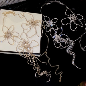 Detail view of sparkling rhinestone flower body chain with elegant tassel fringe accents
