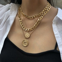 Detail view of multi-layer gold coin pendant necklaces with bold metallic chain layers