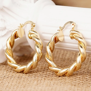 Makroansicht goldener Creolen mit Seilstruktur und sicherem Klappverschluss für Damen