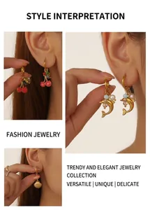 Detailed close-up of colorful enamel cherry and dolphin charms on golden hoop earrings