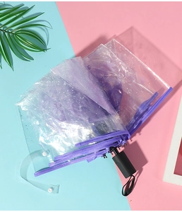Close-up of purple floral pattern on transparent PVC umbrella with black frame detail