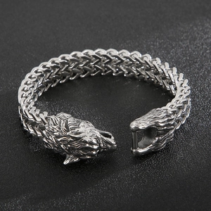 Silver wolf head chain bracelet with braided metal strap for men on dark background