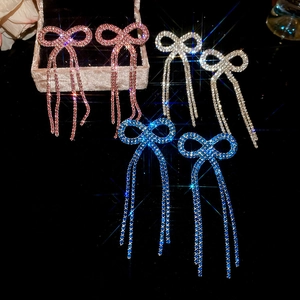 Macro shot of bow tassel earrings in pink, silver and blue with sparkling rhinestones