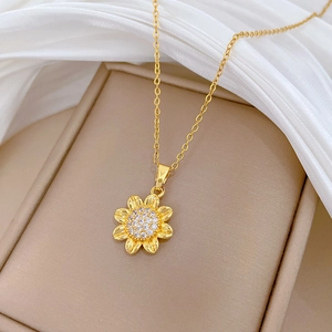 Detail of sunflower pendant necklace in gold with sparkling cubic zirconia on a jewelry pad