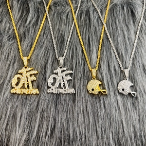 Détail de pendentifs casque de football et OTF sertis de diamants sur chaînes torsadées