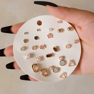 Close-up of geometric stud earring set with pearls and crystals on display card