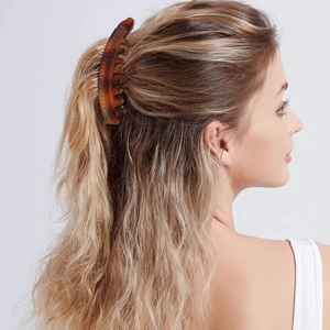 Brown tortoiseshell banana hair clip shown in use for a half-up ponytail hairstyle