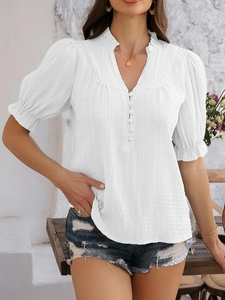 Close-up of white V-neck top with flare half sleeves, button detail and pleated texture