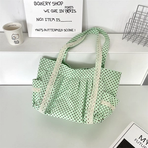 Detail of light green polka dot canvas tote with white lace trim and functional side pockets
