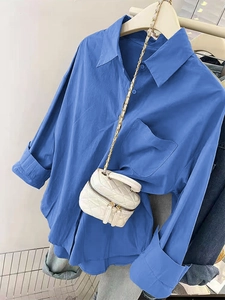 Détail du chemisier bleu à boutons avec poche et sac à bandoulière matelassé blanc à chaîne