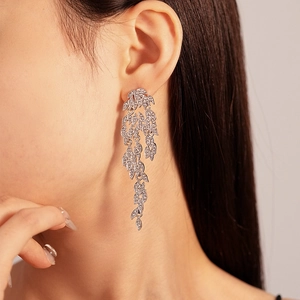 Close-up of model wearing silver leaf tassel earrings with sparkling rhinestones