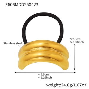 Detail of golden stainless steel hair ring with polished metal finish and black elastic