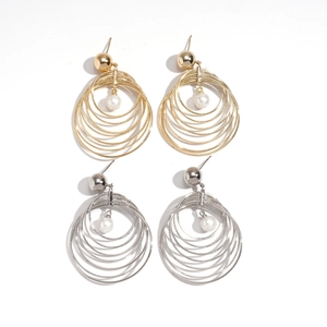 Multi-layered gold and silver hoop earrings with small pearl charms on white background