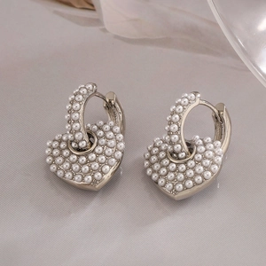 Gros plan de boucles d'oreilles en forme de cœur avec perles et métal argenté