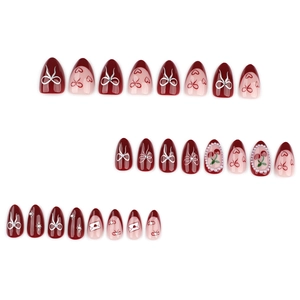 Almond-shaped press-on nails featuring red hearts, bows, cherries, and pearl accents
