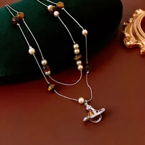 Double-layer pearl and tiger eye stone Saturn necklace on green velvet gift box