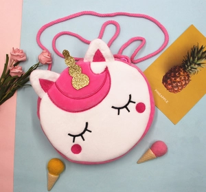Détail du sac licorne en peluche avec corne dorée et bandoulière tressée rose