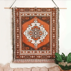 Detail of bohemian woven outdoor blanket with orange geometric patterns and tassels