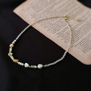 Détails de perles de nacre irrégulières et fermoir doré sur le collier de perles