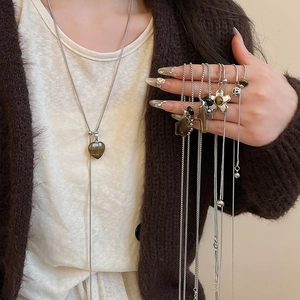 Close-up of stainless steel necklace with tiger eye heart and cross pendants