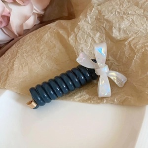 Détail d'un élastique spirale bleu avec nœud iridescent et texte France Handmade