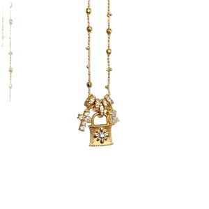 Exquisite gold necklace with zircon lock and cross pendant on a clean white background