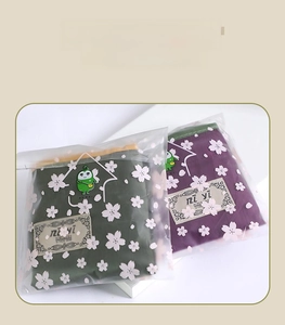 Folded eco-friendly shopping bag in packaging featuring white cherry blossom patterns