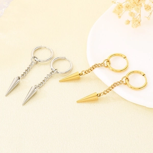 Detail view of gold and silver punk hoop earrings with chain and spike charms