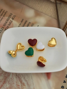 Gold-plated heart-shaped hoop earrings with colorful enamel finishes in a stylish lifestyle setting