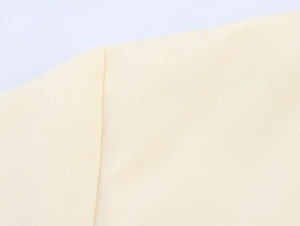 Macro shot of beige cotton linen fabric texture with precision stitching details