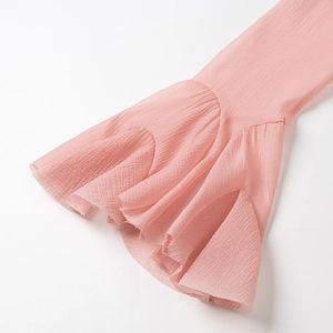 Detailed close-up of pink flared bell sleeves with pleated texture on the dress