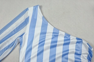 Detail des blau-weiß gestreiften Kleides mit asymmetrischem Mesh-Ärmel und Stoffstruktur
