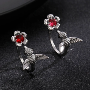 Close-up of vintage hummingbird ring with red gemstone and sparkling zircon accents