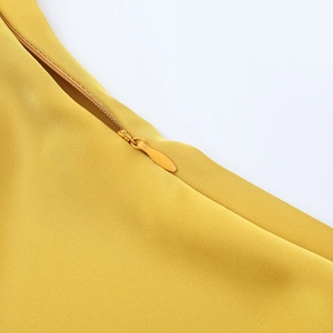 Détail de la fermeture éclair invisible de haute qualité sur la robe de soirée en satin jaune
