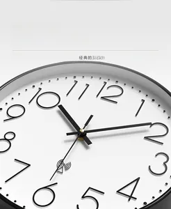 Detail of white 12-inch wall clock with black frame and slim Arabic numerals