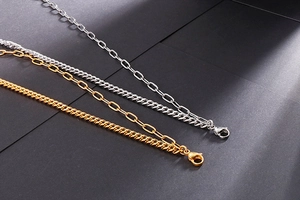 Detail of silver and gold layered cuban and paperclip chain necklaces with round tags