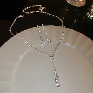 Ensemble élégant collier et boucles d'oreilles argentés avec strass et glands